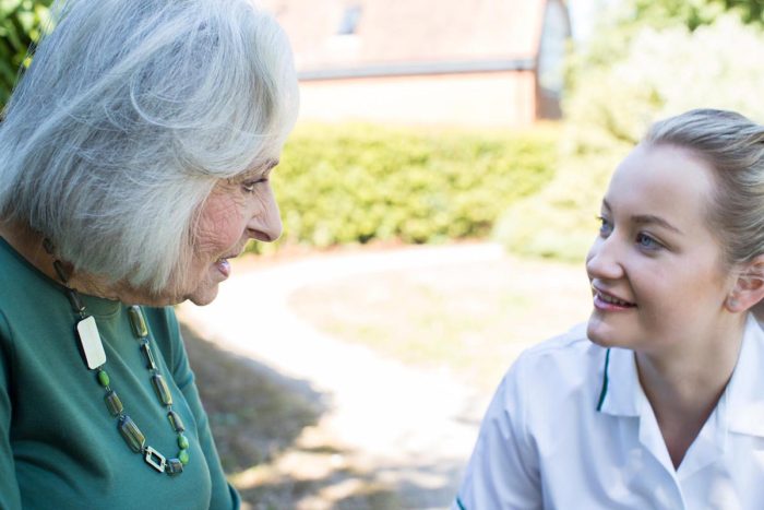 Senior Woman In Garden Talking With Female Carer Senior Woman In Garden Talking With Female Carer